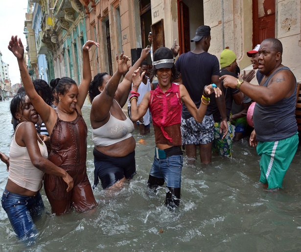 HAB12 LA HABANA (CUBA) 11/09/17.- Foto tomada el 10 de septiembre de 2017, de habitantes que celebran en una calle inundada tras el paso del huracán Irma, en La Habana (Cuba). La zozobra y preocupación con la que los habaneros vivieron el imprevisto acercamiento del huracán Irma a la ciudad dejó paso horas después al característico humor cubano, que afloró tras la tensión y llevó a decenas de personas a hacer de las calles inundadas una improvisada fiesta. EFE/Rolando Pujol