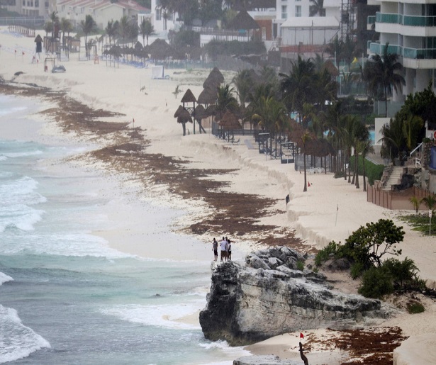 Tourists stand on a rock as subtropical storm Alberto approaches Cancun, Mexico May 25, 2018. REUTERS/Israel Leal
