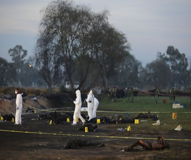 TLAHUELILPAN, MEXICO - JANUARY 19:  (EDITORS NOTE: Image depicts graphic content) A forensic doctor works with burned bodies after an explosion in a pipeline belonging to Mexican oil company PEMEX on January 19, 2019 in Tlahuelilpan, Mexico. In a statement, PEMEX announced that the explosion was caused by the illegal manipulation of the pipeline, as minutes before the accident videos were shot where people could be seen filling drums and car fuel tanks.  (Photo by Hector Vivas/Getty Images)