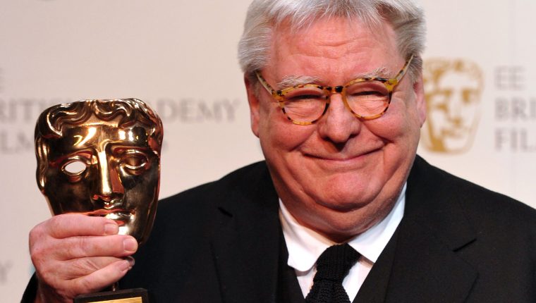 (FILES) In this file photo taken on February 10, 2013 British film director, producer and writer Alan Parker (L) poses with his BAFTA fellowship award during the annual BAFTA British Academy Film Awards at the Royal Opera House in London on February 10, 2013. - British director Alan Parker, whose long list of hits over the decades has included "Midnight Express" and "The Commitments", died on July 31, 2020 at the age of 76, his family said. (Photo by CARL COURT / AFP)