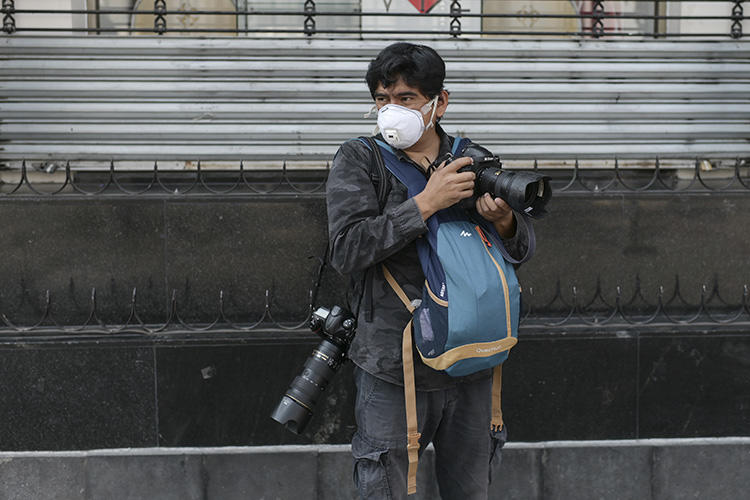 Mexican AFP photographer Alfredo Estrella wears a face mask as he works during the pandemic of the novel coronavirus COVID-19, in Mexico City, on April 8, 2020. (Photo by PEDRO PARDO / AFP)