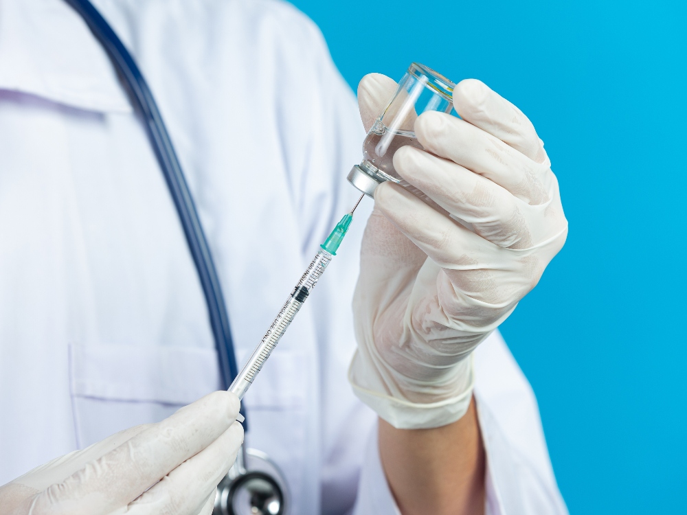 close up picture of doctor's hands holding hypodermic syringe