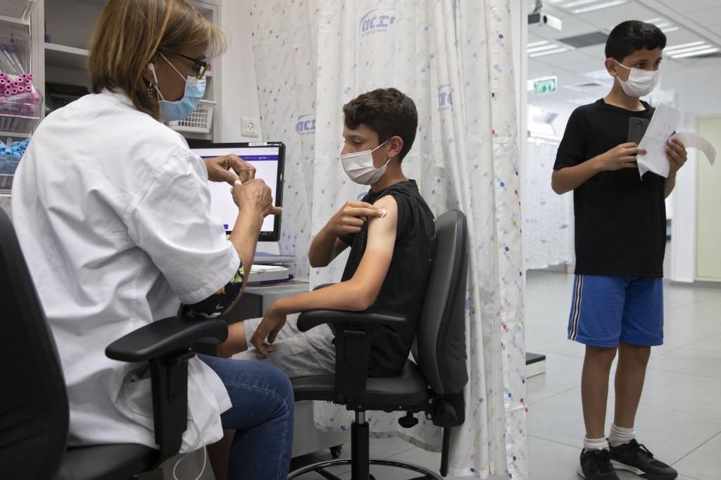 An Israeli youth receives a Pfizer-BioNTech COVID-19 vaccine in the central Israeli city of Rishon LeZion, Sunday, June 6, 2021. Israel started vaccinating children from 12 to 15 on Sunday. (AP Photo/Sebastian Scheiner)