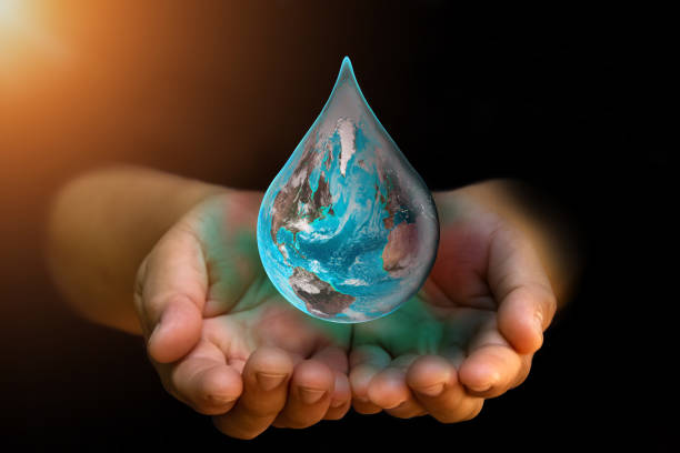 Blue Earth world with dripping water on two hand at wait on abstract black background. Water shortage and earth day concept or world water day. Elements of this image furnished by NASA.