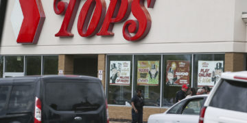 A crowd gathers as police investigate after a shooting at a supermarket on Saturday, May 14, 2022, in Buffalo, N.Y. Multiple people were shot  at the Tops Friendly Market.  Police have notified the public that the alleged shooter was in custody. (AP Photo/Joshua Bessex)