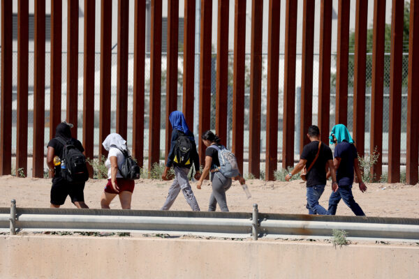 EL PASO, TEXAS - SEPTEMBER 21: Migrants walk along the U.S. border fence to turn themselves in to the U.S. Border Patrol after crossing the Rio Grande from Mexico on September 21, 2022 in El Paso, Texas. In recent weeks, Venezuelans have arrived in increasing numbers in El Paso. The city has had to scramble to find housing and other aid for the migrants.  (Photo by Joe Raedle/Getty Images)