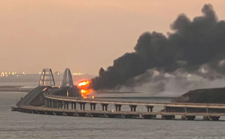 A view shows a fire on the Kerch bridge at sunrise in the Kerch Strait, Crimea, October 8, 2022. REUTERS/Stringer